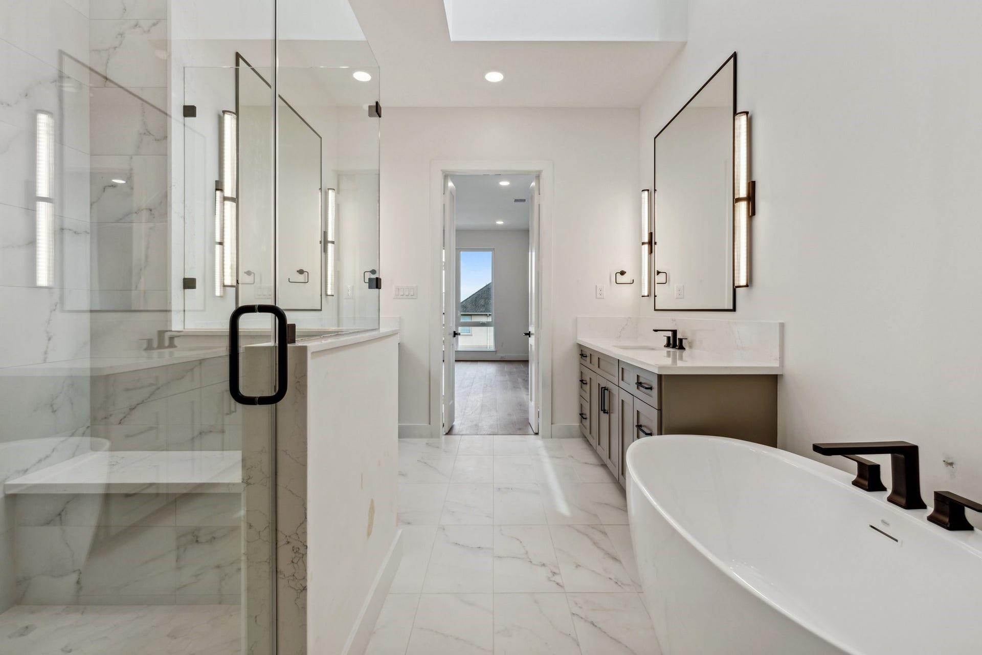 Another view of this to-die-for primary bath. Enjoy the 5-foot freestanding soaking tub, spacious walk-in shower with shampoo niches and built-in bench.