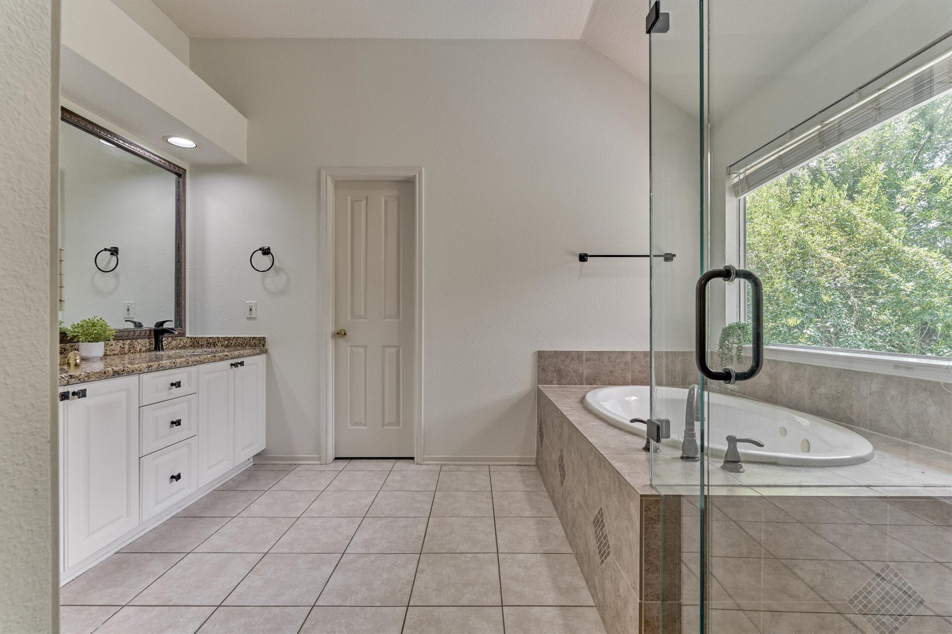 11 Vinca Trail, The Woodlands, TX 77382 The large primary en-suite bathroom with dual vanity area, a glass shower and soaking tub.