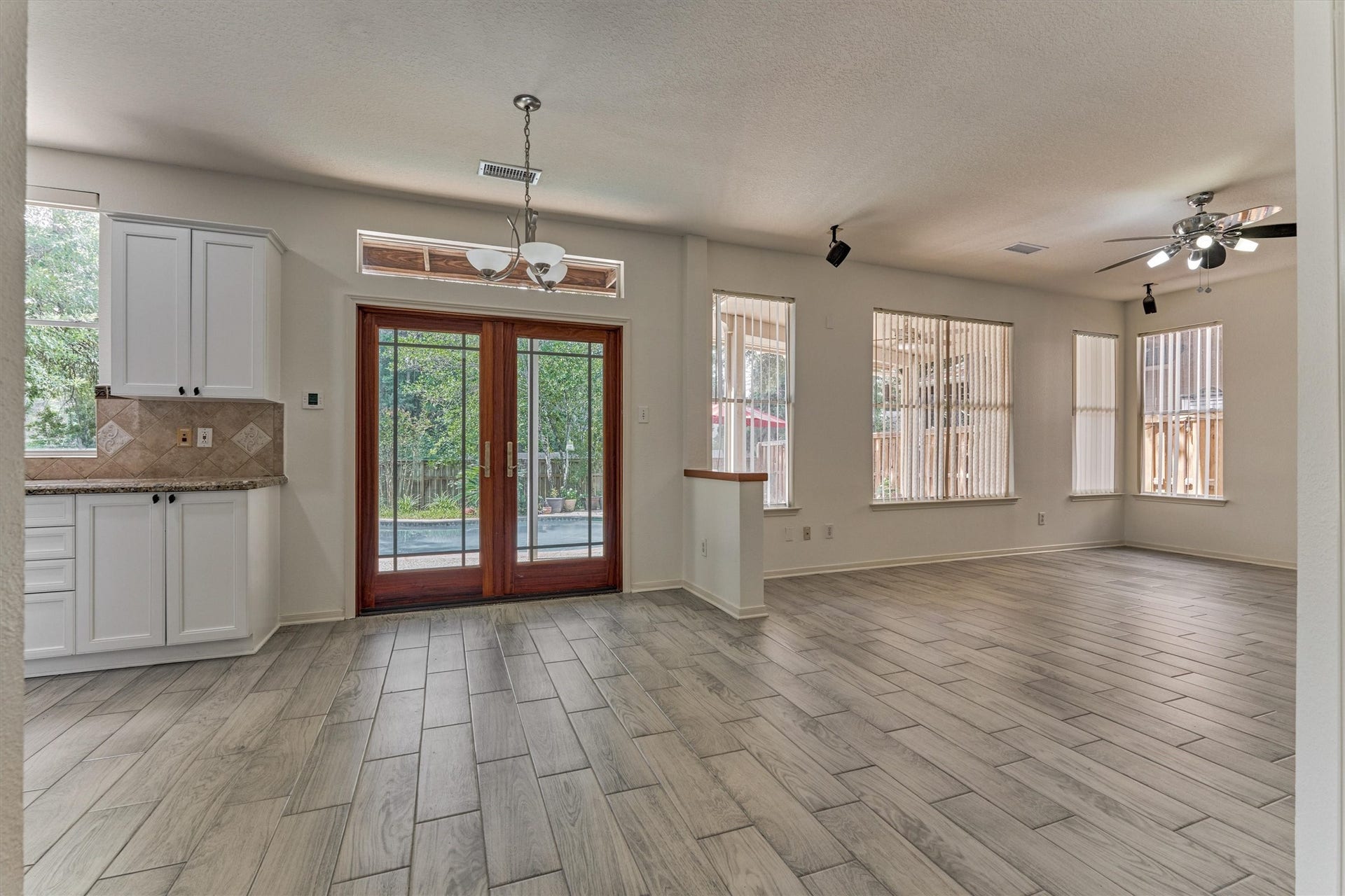 11 Vinca Trail, The Woodlands, TX 77382 The home has an open floorplan and flows beautifully! The large glass french doors lead out to the covered rear patio and pool.