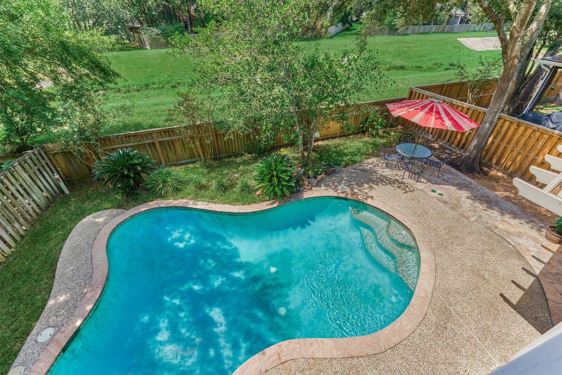 11 Vinca Trail, The Woodlands, TX 77382 A view of the pool and backyard form the balcony. There are no rear neighbors.