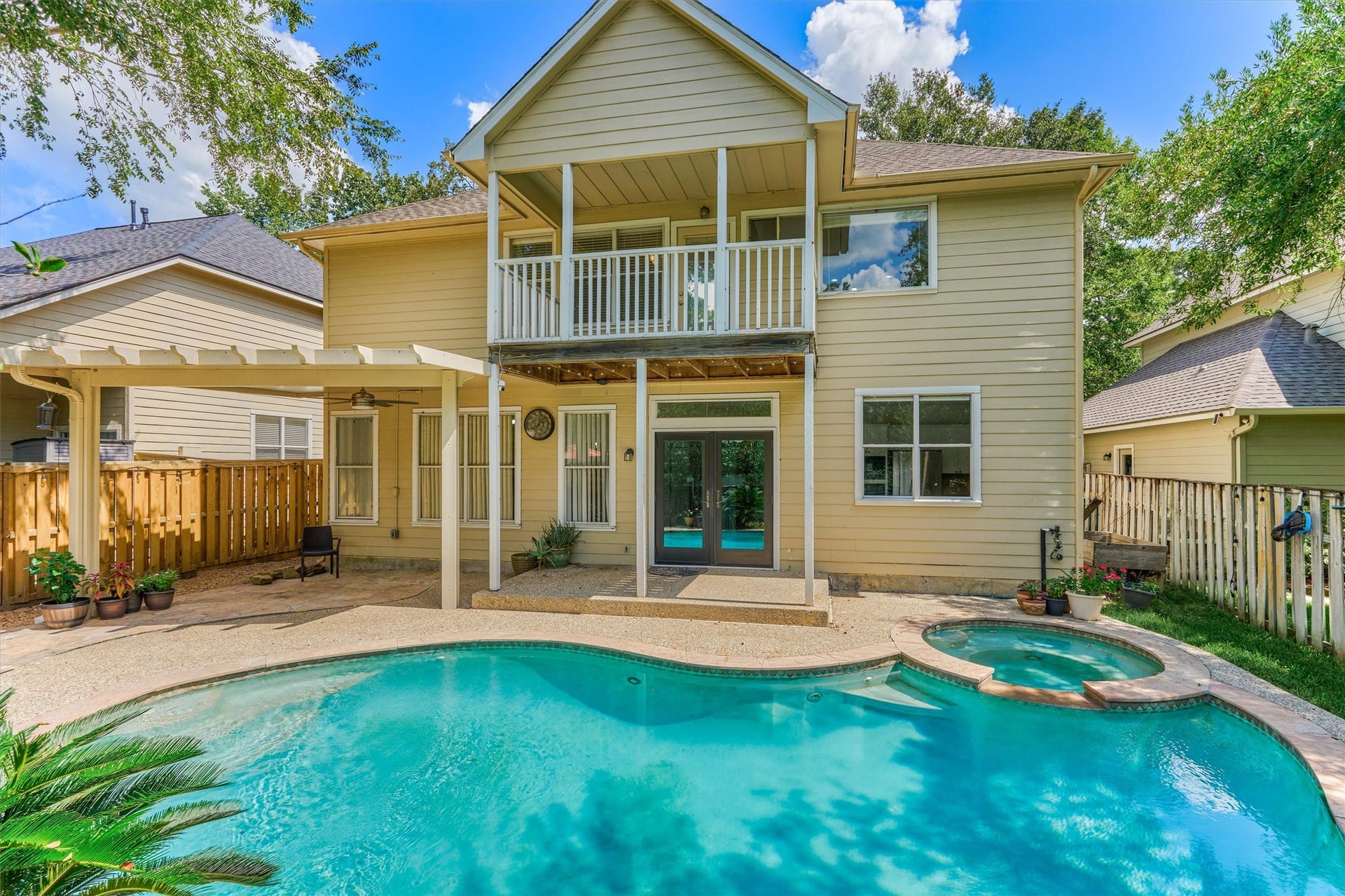 11 Vinca Trail, The Woodlands, TX 77382 The backyard with the sparkling saltwater pool & spa! The spacious covered patio area and balcony off the second floor primary bedroom with allow you to cool off and stay shaded.