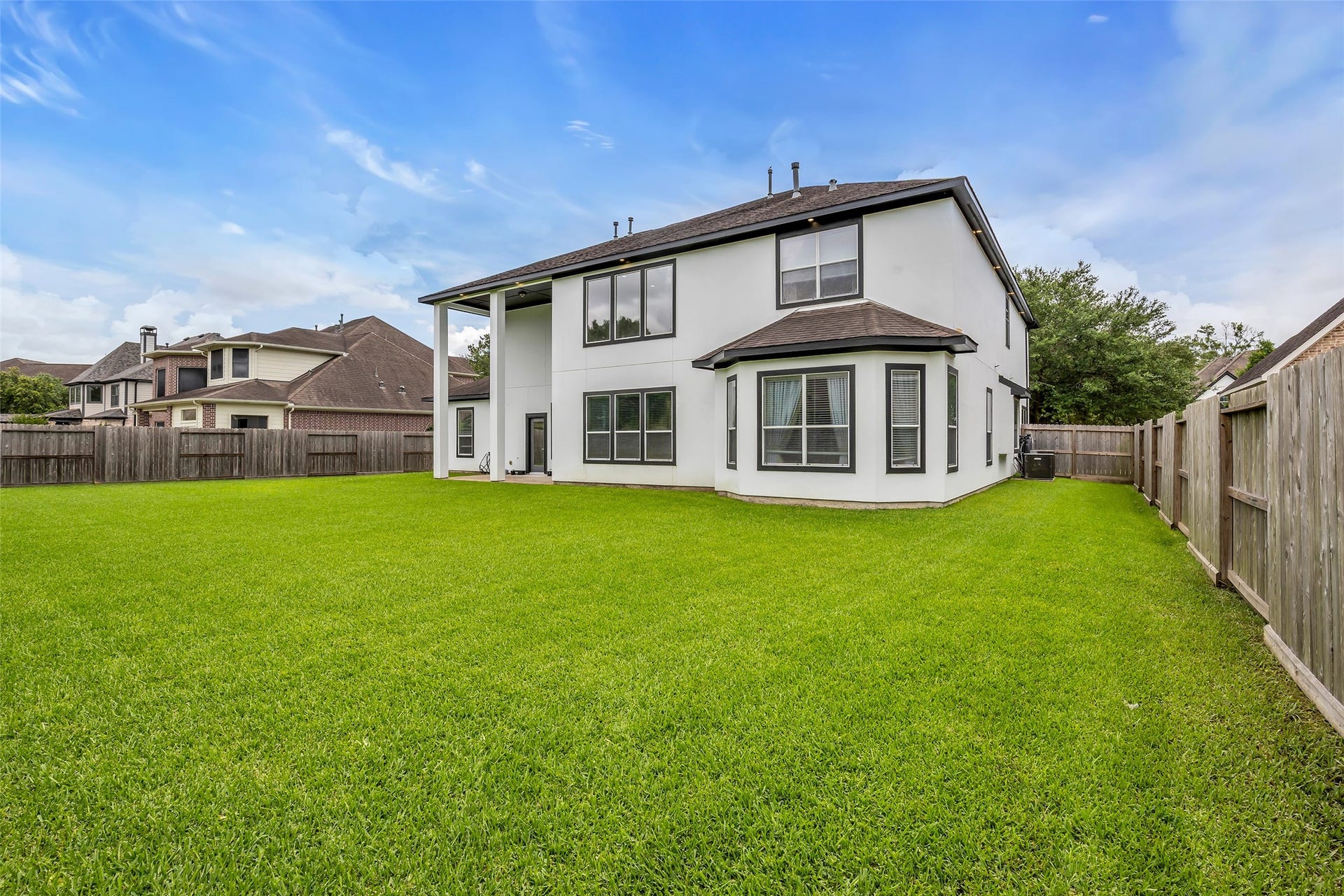 3314 Sussex Way, Friendswood, TX 77546 The backyard features lush green grass and is fully enclosed by a wooden fence, providing a well-defined outdoor space.