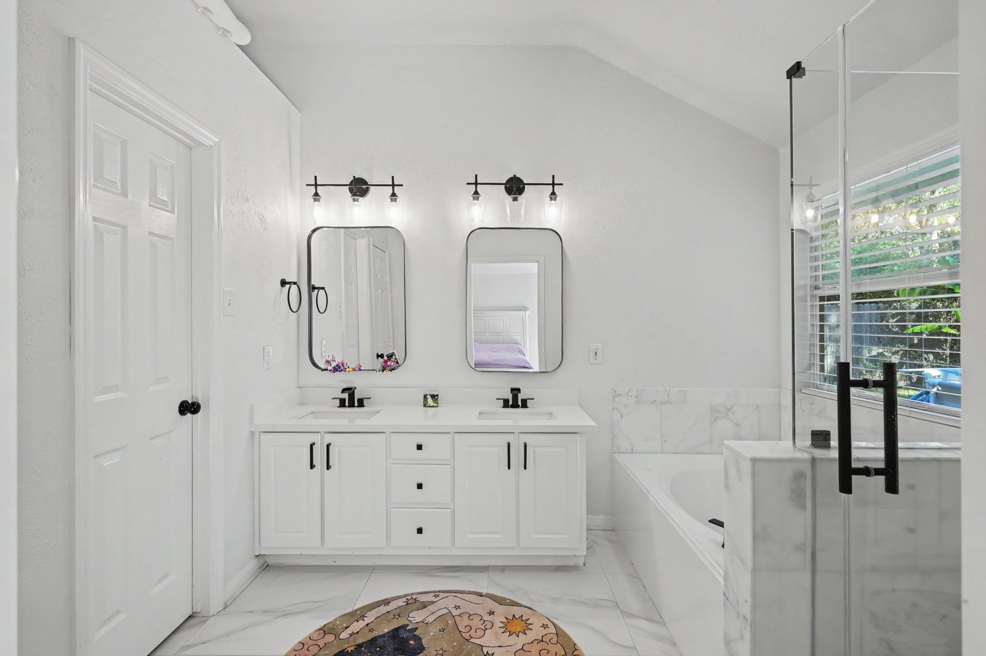 Primary bath with double sinks, matching mirrors, and separate tub and shower