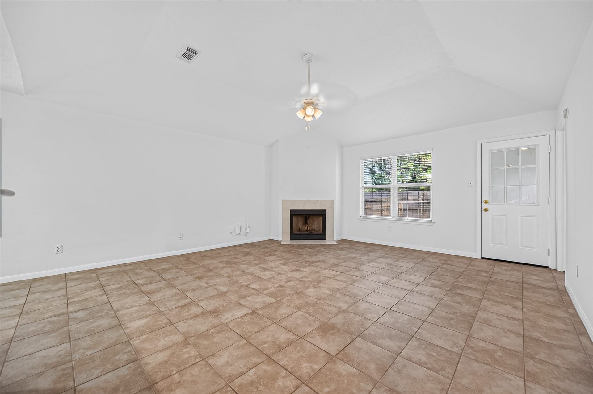2703 Blue Mist Drive, Sugar Land, TX 77498 Spacious open-concept kitchen and living area featuring a sleek stainless steel refrigerator, cozy fireplace, and abundant natural light.
