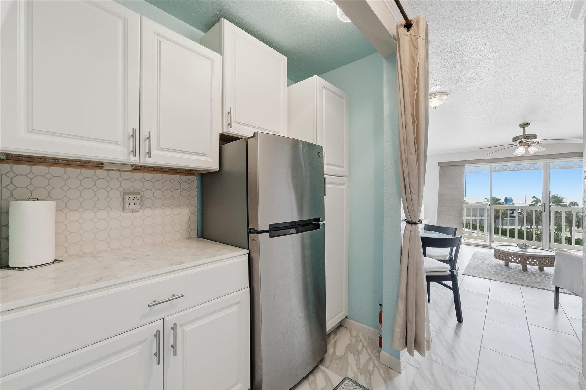 6300 Seawall Boulevard, #9321, Galveston, TX 77551 Kitchen with white cabinetry and a stainless refrigerator, open to the living area