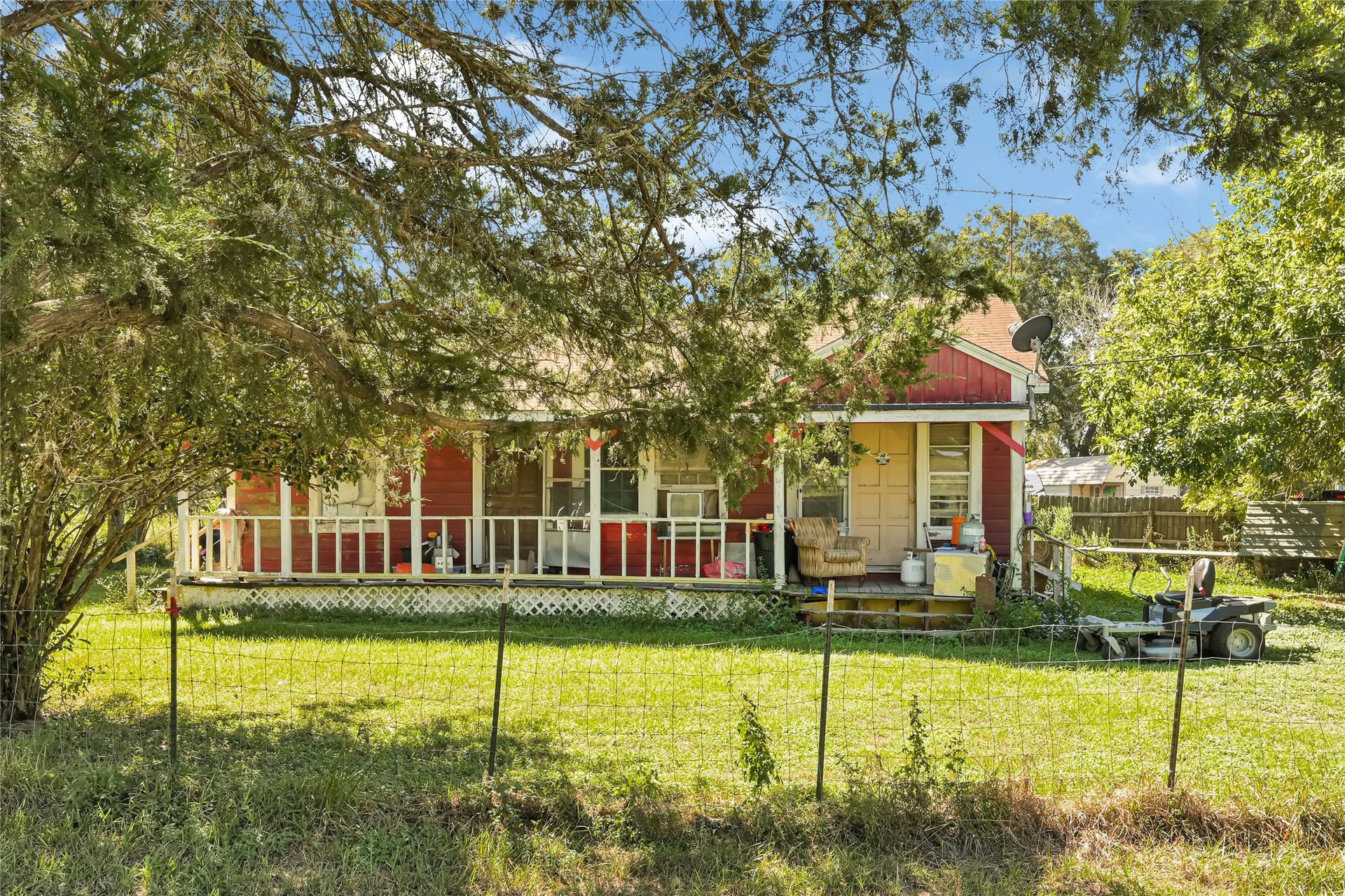 121 Patterson Road, Brazoria, TX 77422 Charming rustic home with a welcoming front porch, surrounded by lush greenery, offering a serene country feel.