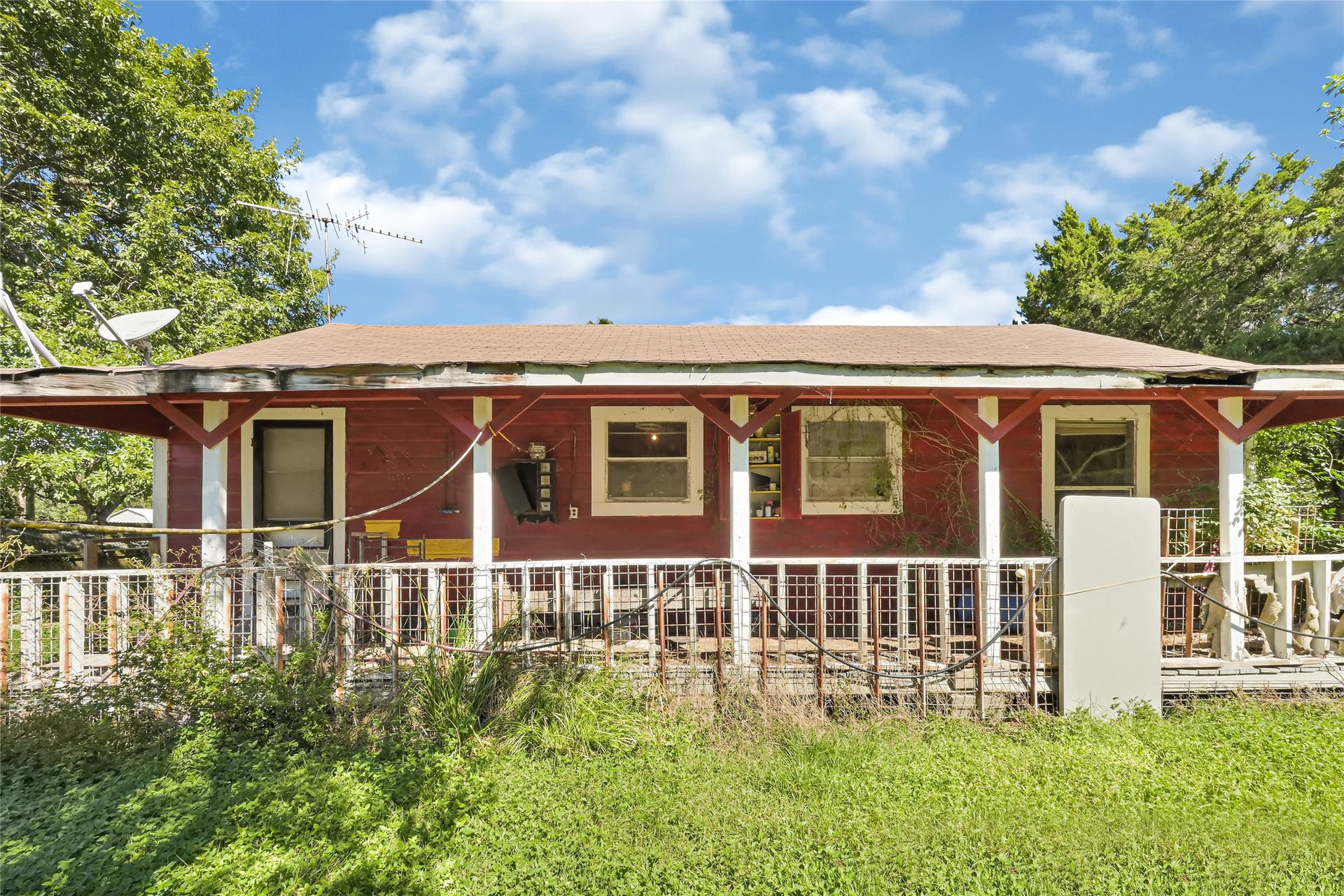 121 Patterson Road, Brazoria, TX 77422 Charming rustic home with a spacious front porch, set amidst lush greenery for a serene retreat.