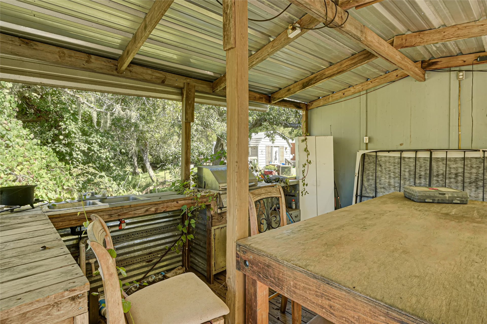 121 Patterson Road, Brazoria, TX 77422 Rustic outdoor workspace with a covered seating area and views of lush greenery, perfect for creative projects or relaxation.