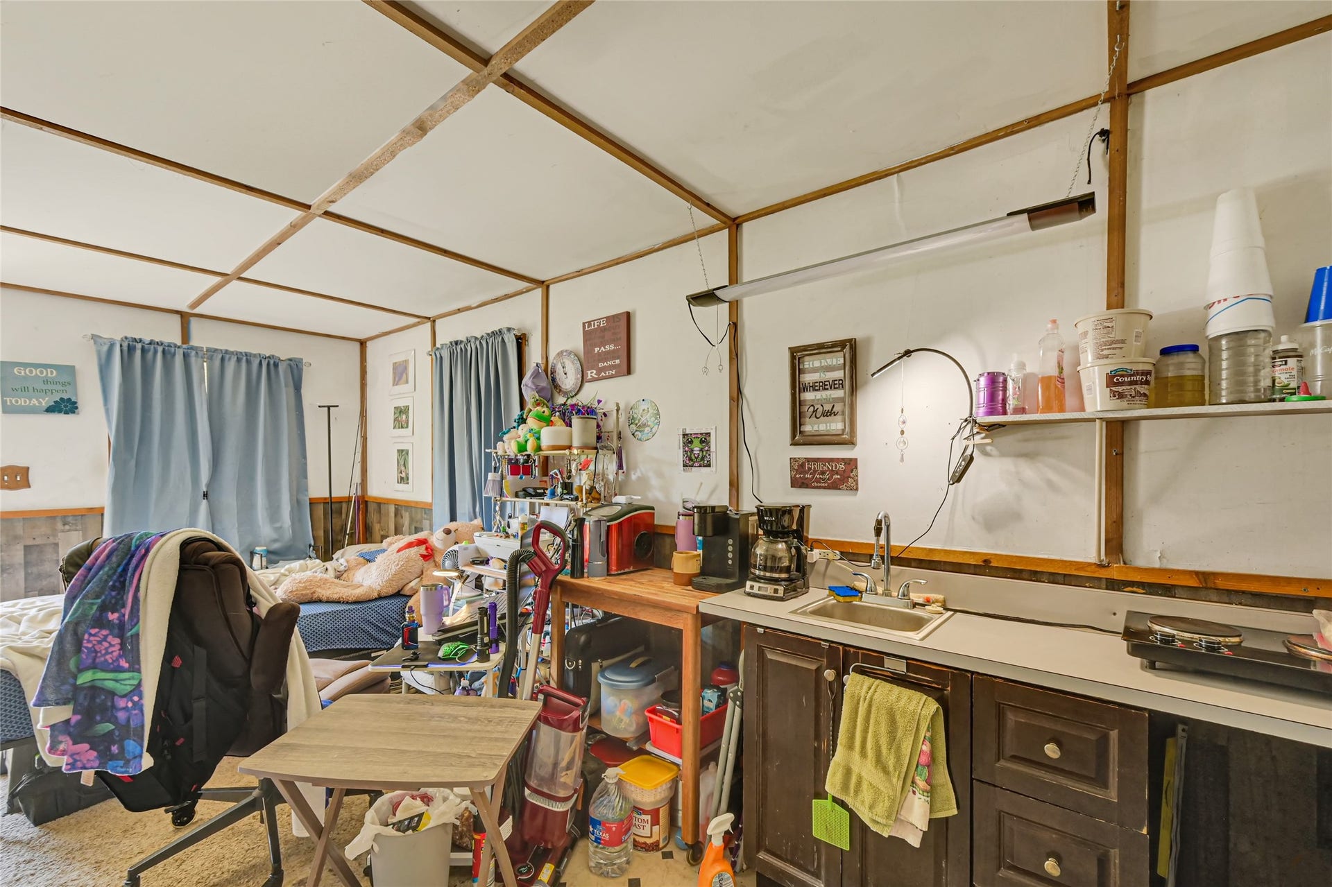 121 Patterson Road, Brazoria, TX 77422 Cozy multipurpose room featuring a compact kitchenette, ample shelving, and a comfortable seating area, perfect for relaxation or hobbies.