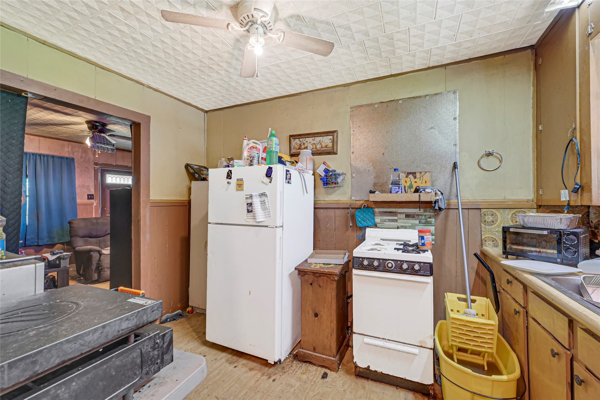 121 Patterson Road, Brazoria, TX 77422 Cozy kitchen space with vintage charm, featuring a classic gas stove, ample cabinetry, and adjoining living area.