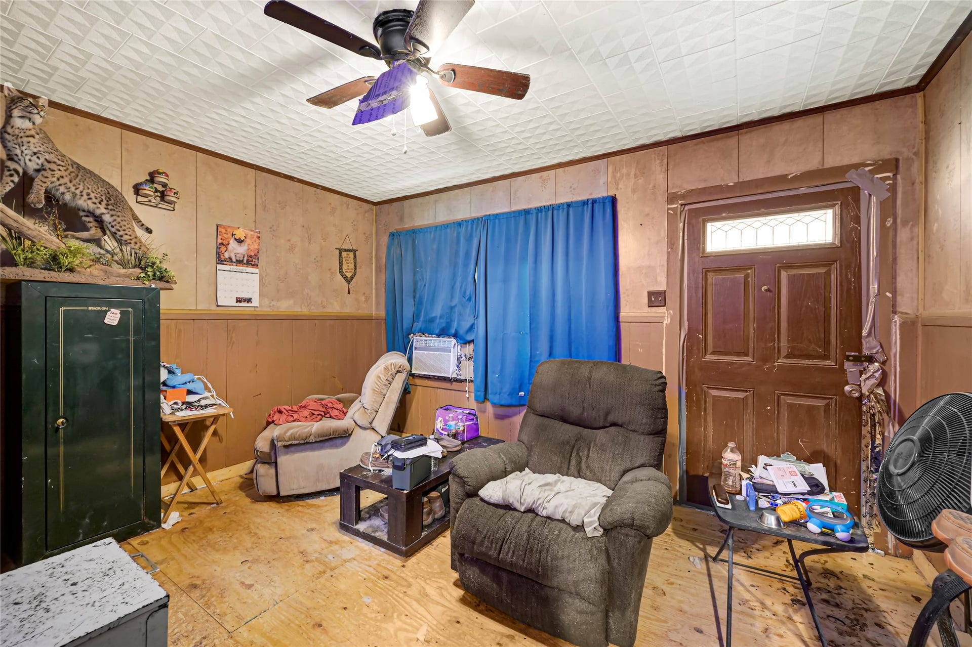 121 Patterson Road, Brazoria, TX 77422 Cozy living space featuring wood paneling, a ceiling fan, and comfortable seating, perfect for relaxation.