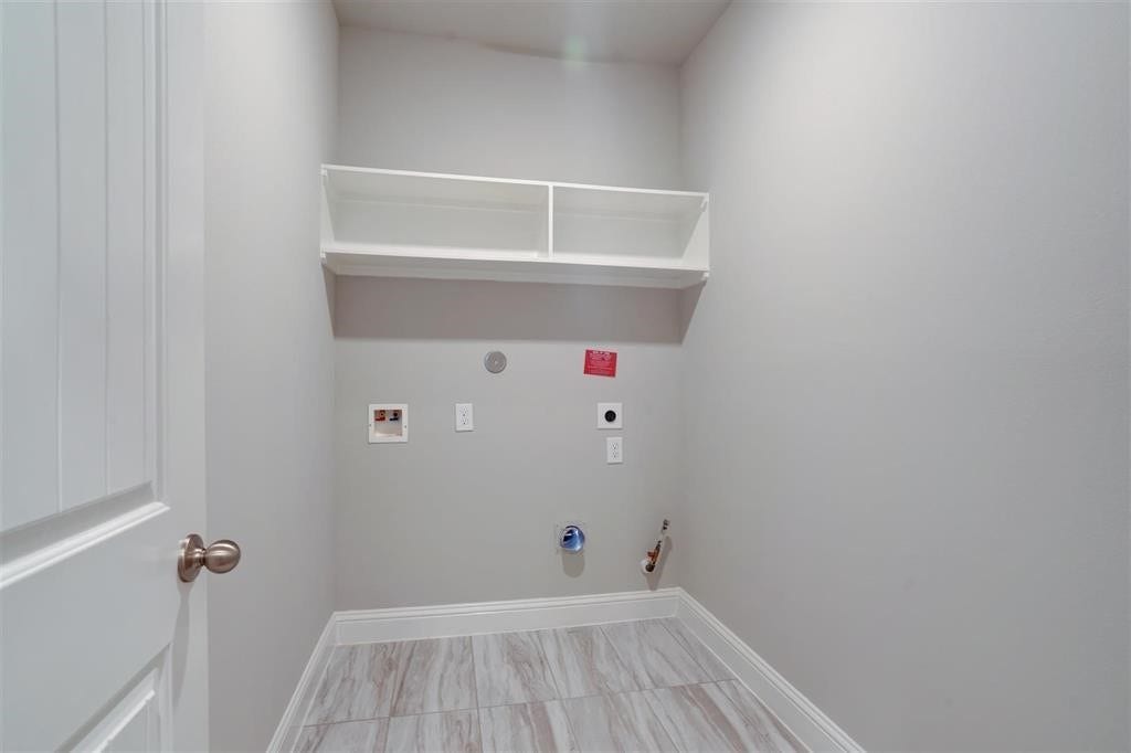 23715 Ruby Bramble Trail, Katy, TX 77493 Spacious laundry room with tile flooring, built-in shelving, and connections for washer and dryer.