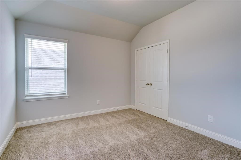 23715 Ruby Bramble Trail, Katy, TX 77493 Cozy secondary bedroom with soft carpeting, neutral walls, and ample natural light from a well-placed window, complemented by a double-door closet for convenient storage.
