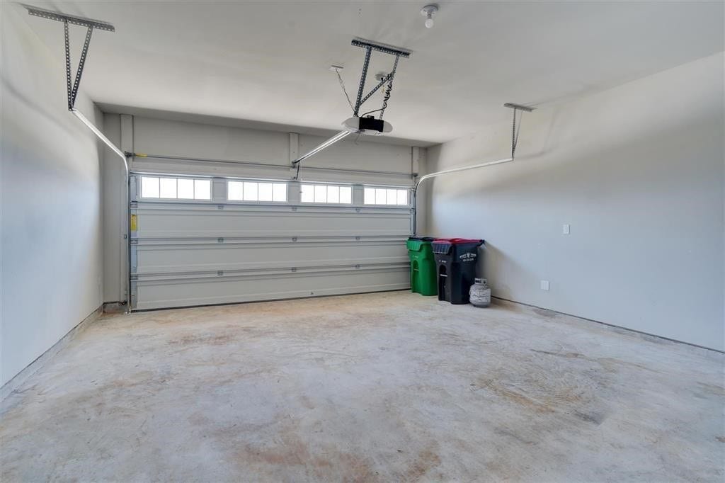 23715 Ruby Bramble Trail, Katy, TX 77493 Spacious two-car garage with ample storage potential, featuring a modern sectional door with windows for natural light.