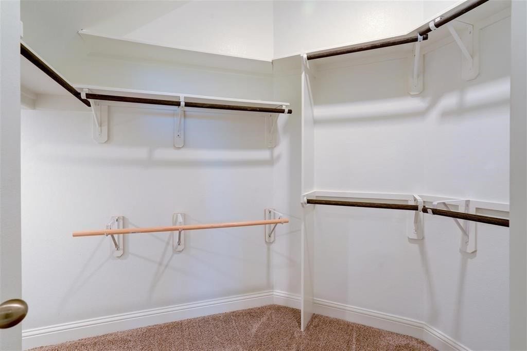 23715 Ruby Bramble Trail, Katy, TX 77493 Spacious walk-in closet featuring multiple hanging rods and shelves, perfect for organizing your wardrobe.
