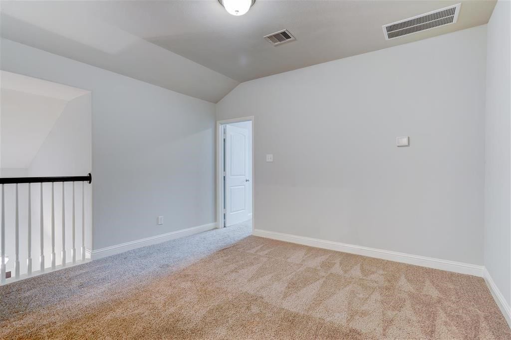 23715 Ruby Bramble Trail, Katy, TX 77493 Bright and spacious carpeted loft area with neutral walls, perfect for a cozy sitting room or office space, featuring a modern railing and convenient access to an adjoining room.