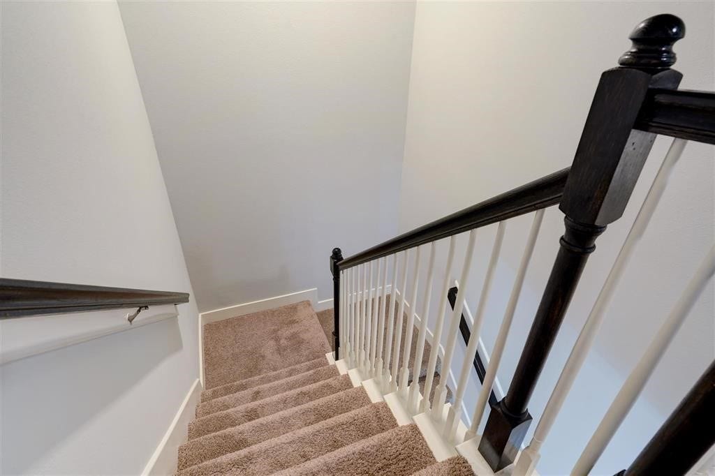 23715 Ruby Bramble Trail, Katy, TX 77493 Elegant staircase with plush carpet and dark wood accents offers a warm transition between floors.