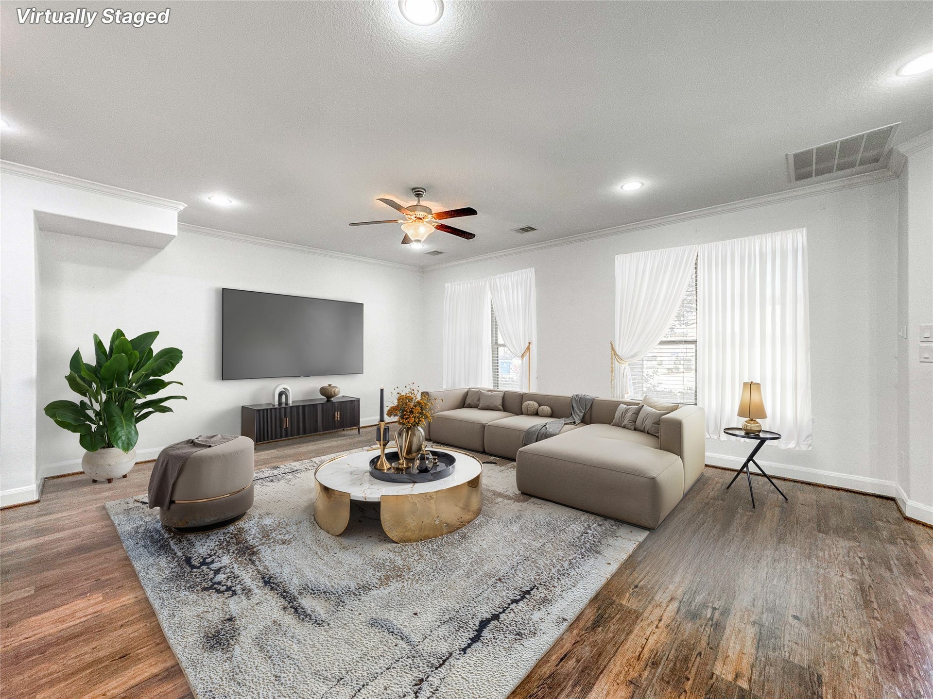 Welcome home to a spacious (virtually staged) living room with luxury vinyl flooring, with enough room for a large sectional sofa. It features a ceiling fan, large windows for natural light which is welcoming and makes a comfortable space.