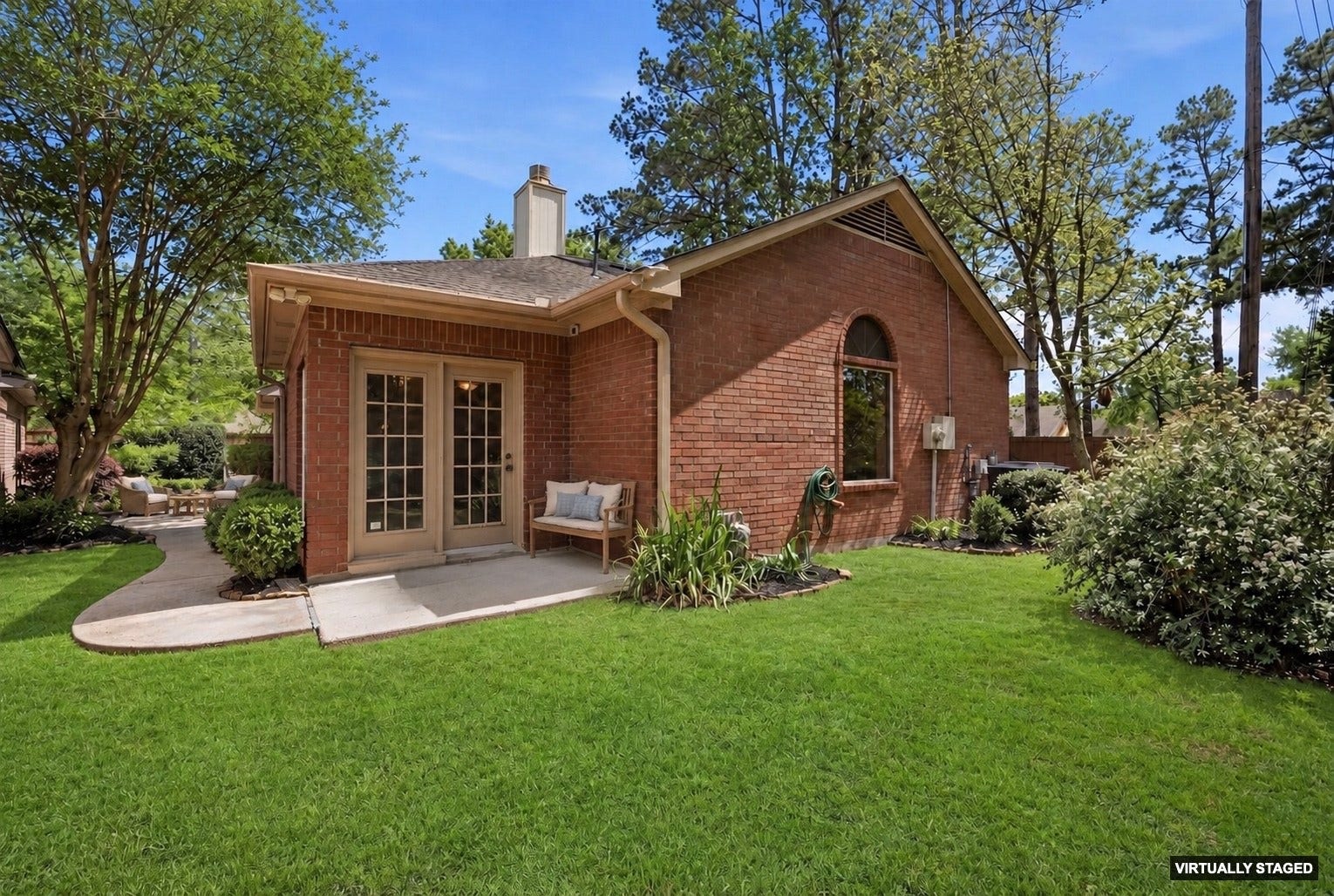 3203 Hickory Brook Lane, Houston, TX 77345 Rear view showing the patio, lawn and mature trees. Virtually Staged