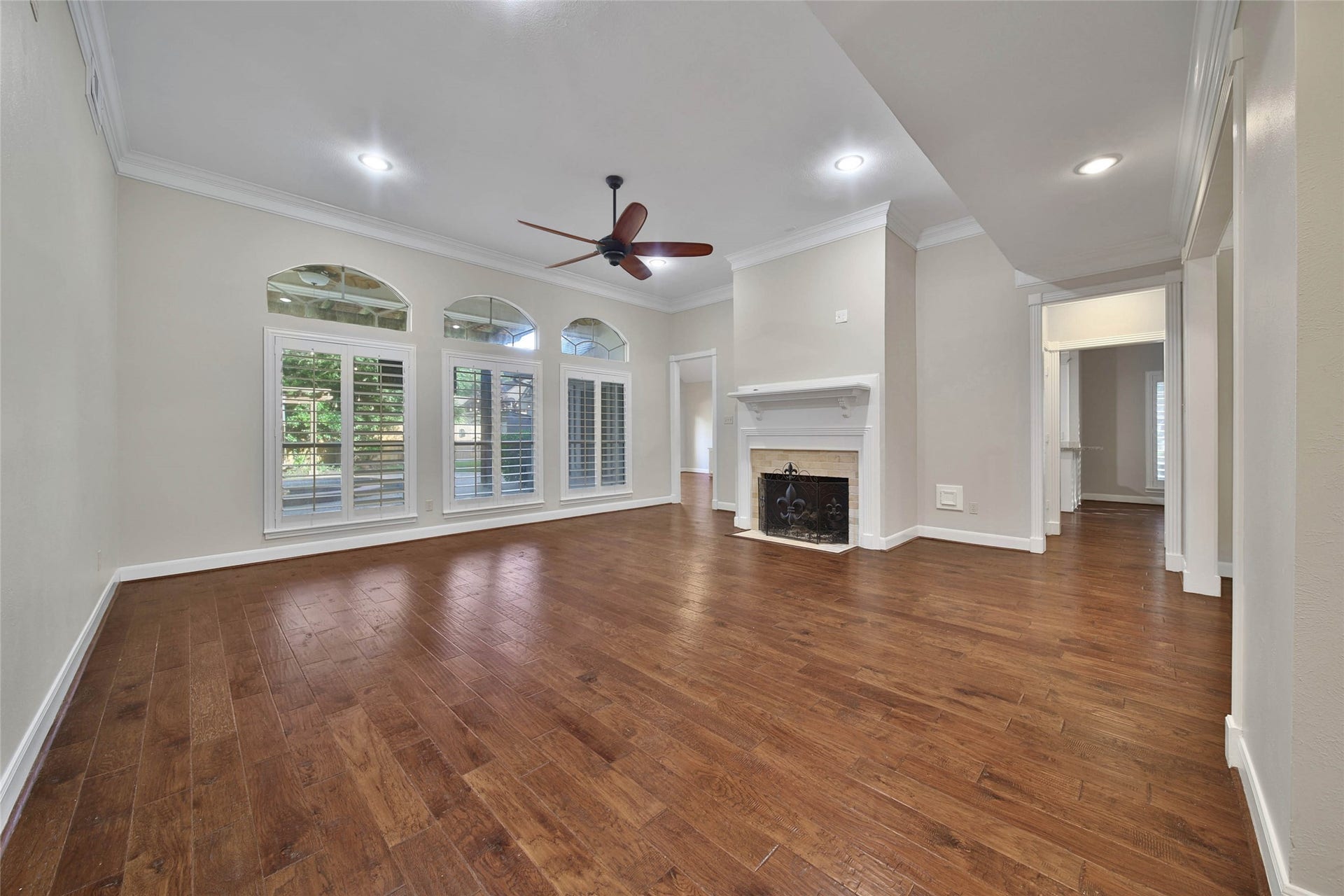 5814 Woodland Creek Drive, Kingwood, TX 77345 This outstanding living room showcases the beautiful hardwood floors. High ceilings, large windows overlooking the patio and pool, plantation shutters, recessed lighting and gaslog fireplace make this a comfortable place to relax or entertain.