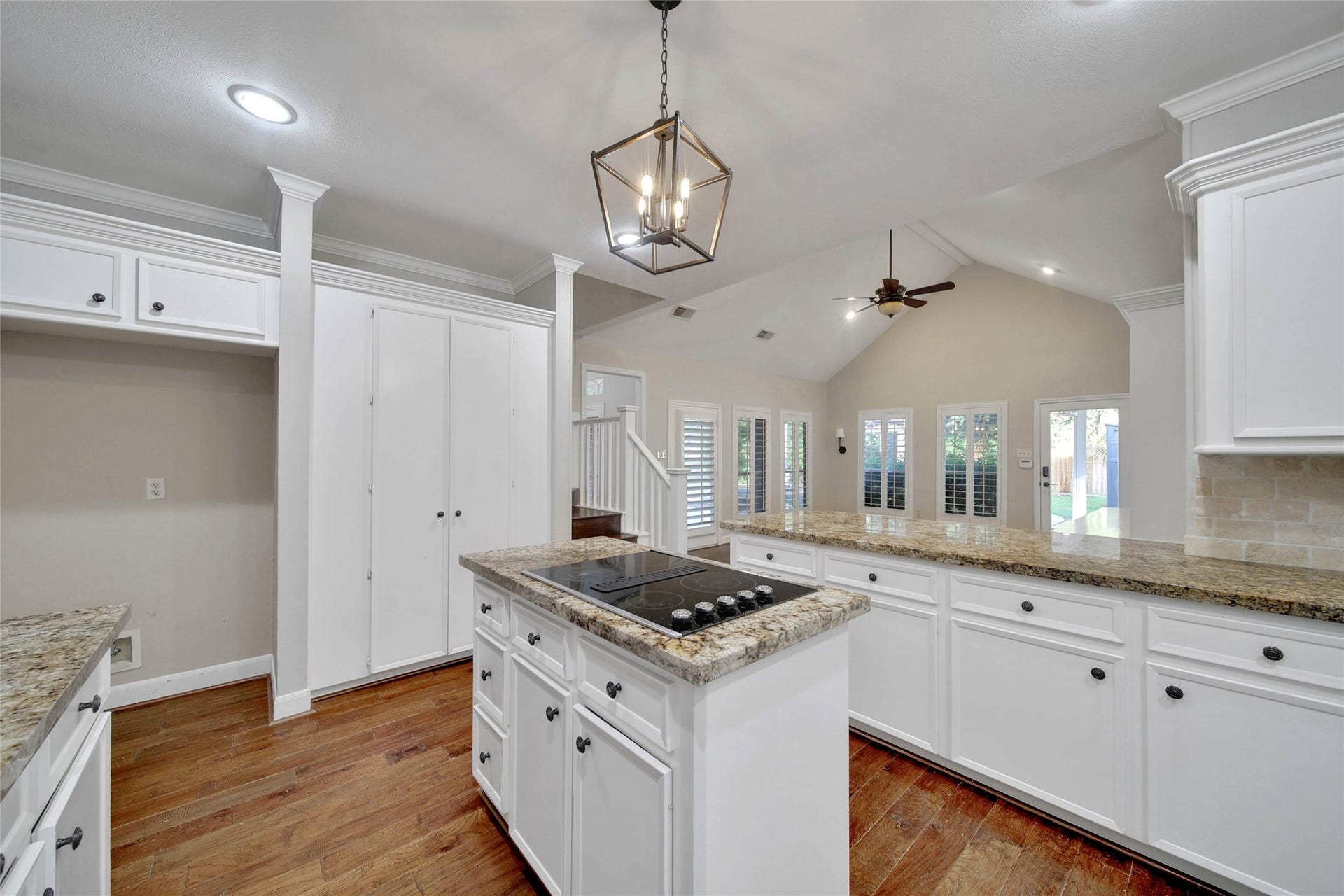 5814 Woodland Creek Drive, Kingwood, TX 77345 The gorgeous hardwood floors stand out in the kitchen. The kitchen features granite counters, travertine subway tile backsplash, and recessed lighting. The hardwood flooring is carried up the staircase to the second floor.