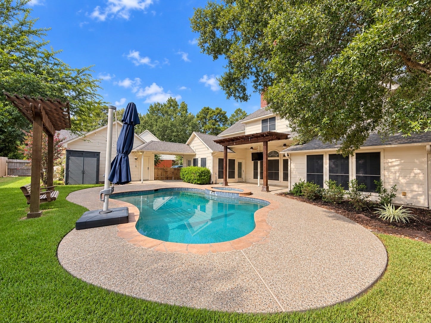 5814 Woodland Creek Drive, Kingwood, TX 77345 Large private backyard, with Sparkling Pebble Tec Pool and Spa, covered patio, pergola, and lots of yard space leftover.