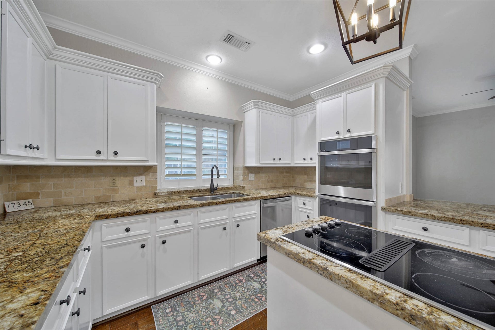 5814 Woodland Creek Drive, Kingwood, TX 77345 Kitchen appliances include GE Profile double wall ovens, downdraft island cooktop and GE Profile dishwasher.