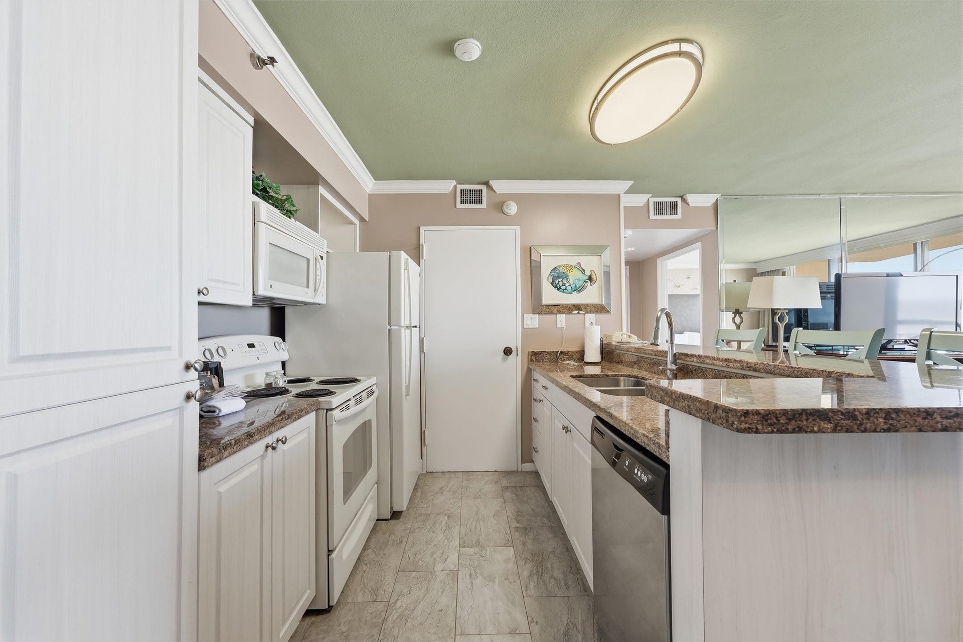 5220 Seawall Boulevard, #1233D, Galveston, TX 77551 The kitchen offers white cabinetry, generous counter space, and a convenient breakfast bar.