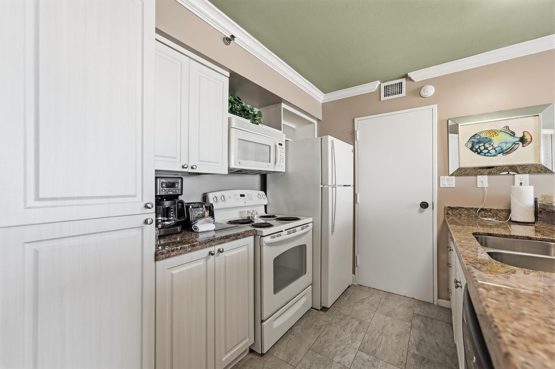 5220 Seawall Boulevard, #1233D, Galveston, TX 77551 A refrigerator, electric range, and built-in microwave make this kitchen ready for your culinary ventures.
