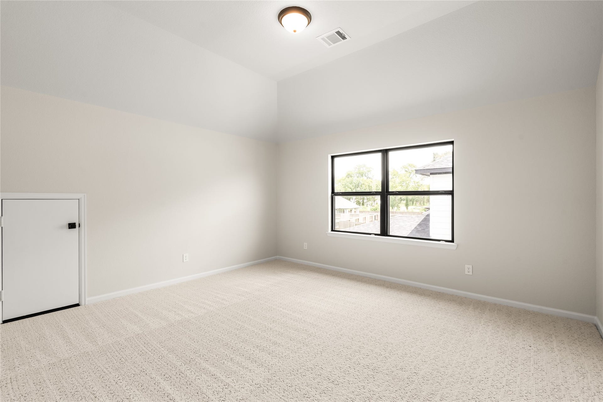 9607 Maple Wood Drive, Missouri City, TX 77459 Spacious, light-filled room with plush carpeting, high ceilings, and a large window.