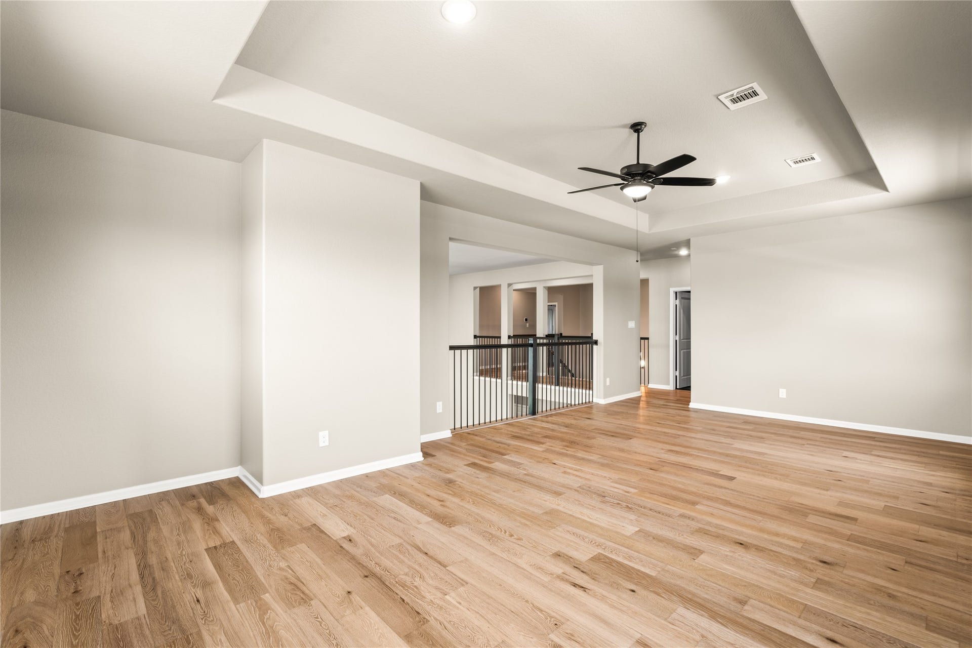 9607 Maple Wood Drive, Missouri City, TX 77459 Spacious open-concept living area that will become the hub of your home. This central space features beautiful hardwood floors, a modern ceiling fan, high ceilings, and ample natural light, perfect for entertaining or relaxing.