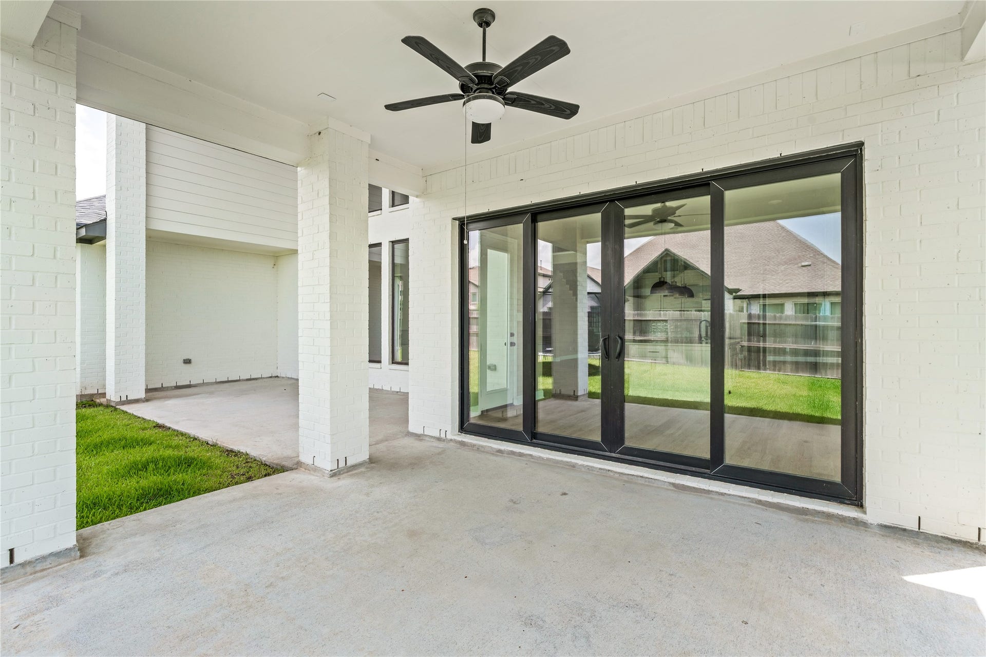 9607 Maple Wood Drive, Missouri City, TX 77459 Spacious covered patio with modern ceiling fan and expansive sliding glass doors, perfect for seamless indoor-outdoor living.