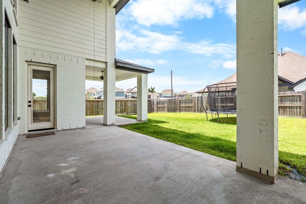 9607 Maple Wood Drive, Missouri City, TX 77459 Spacious covered patio overlooking a lush backyard, perfect for outdoor activities and relaxation.