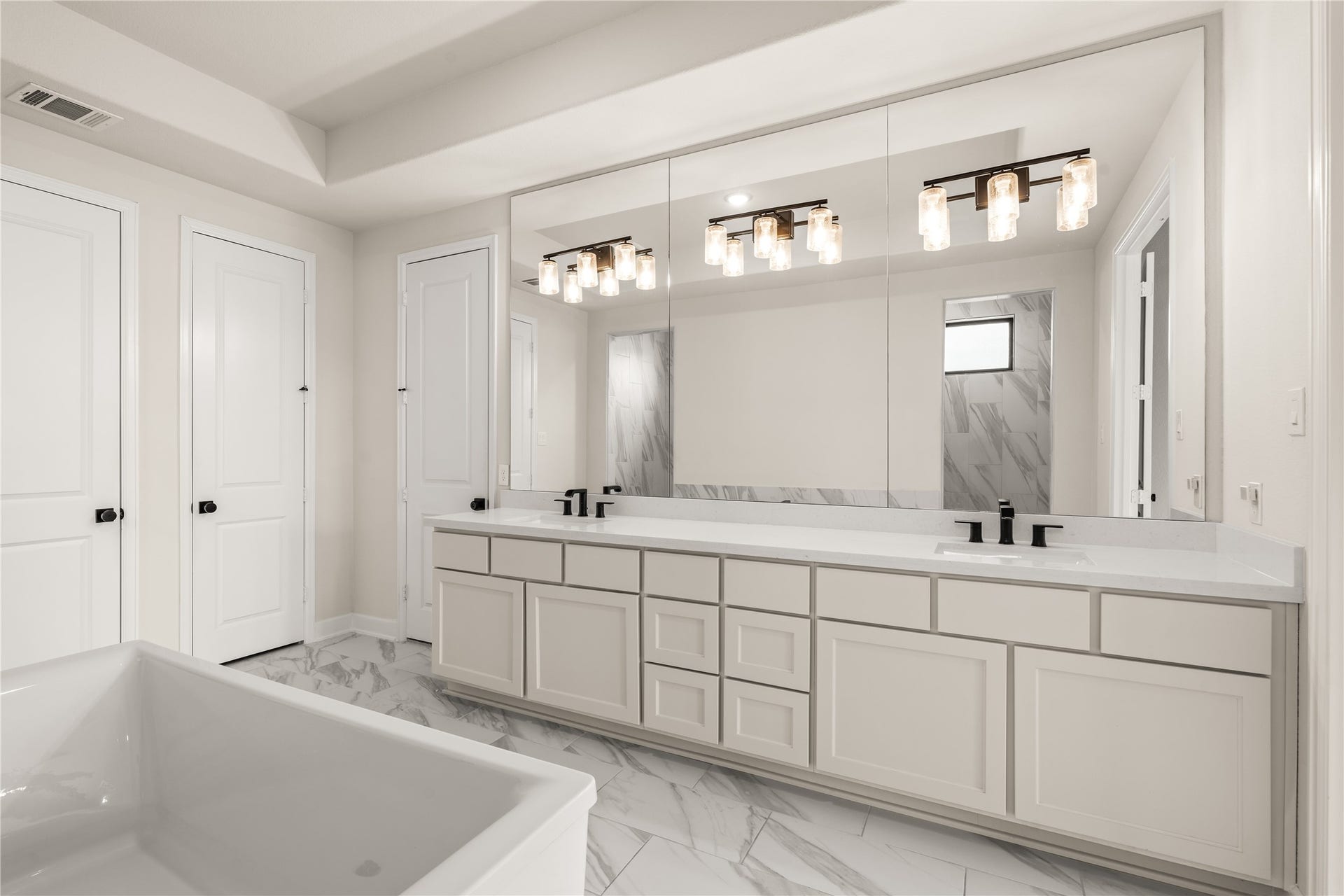 9607 Maple Wood Drive, Missouri City, TX 77459 Splendid primary bathroom featuring a spacious double vanity with modern fixtures, elegant lighting, and ample cabinetry, all set against a backdrop of marble flooring.