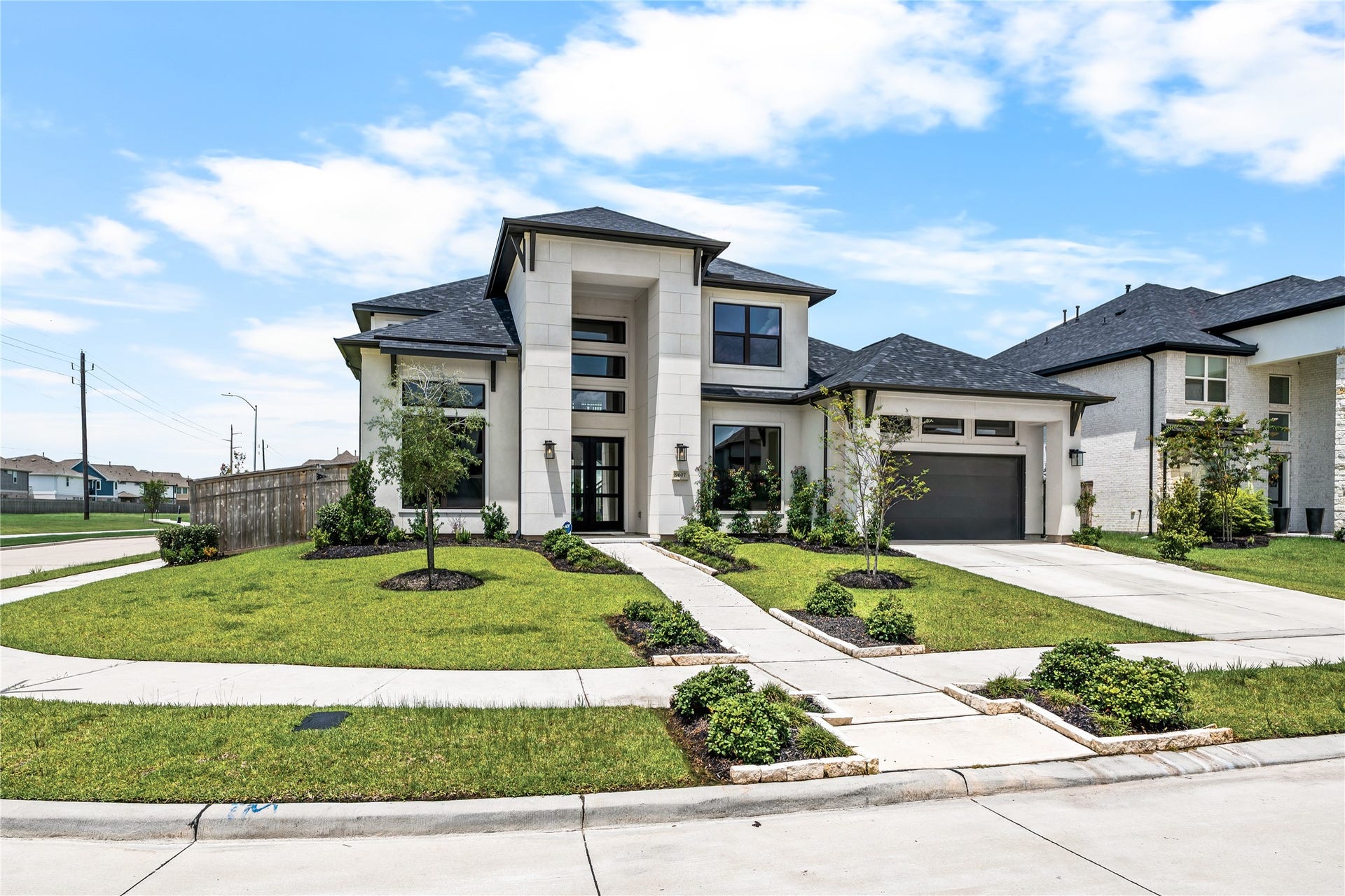 9607 Maple Wood Drive, Missouri City, TX 77459 Stunning modern two-story home with sleek architectural design, expansive windows, and a manicured front yard, situated in a desirable neighborhood.