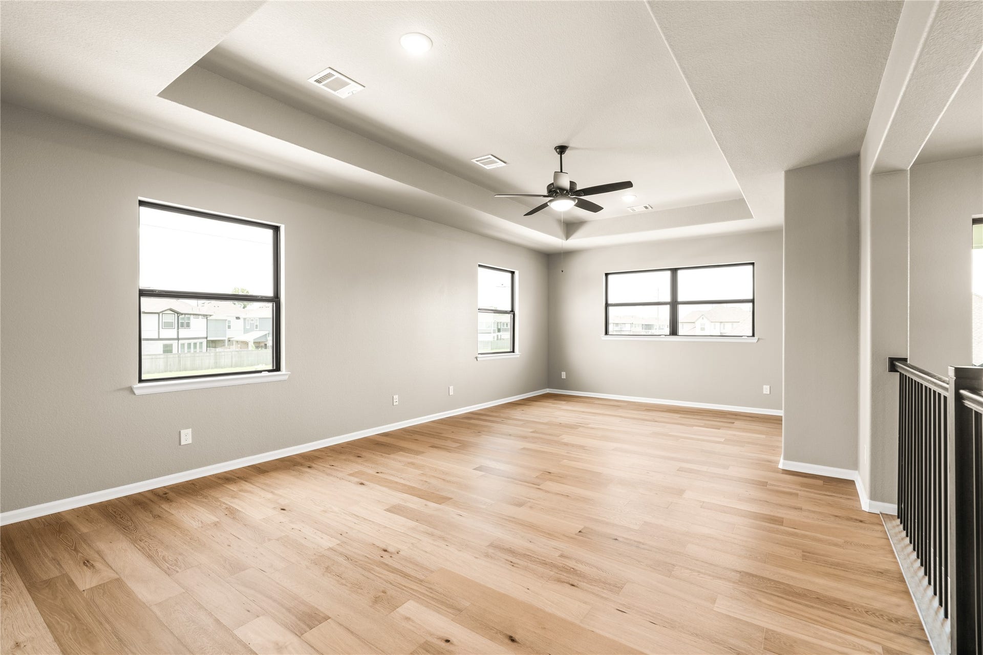 9607 Maple Wood Drive, Missouri City, TX 77459 Spacious and bright loft /gameroom area with elegant wood flooring, a modern ceiling fan, high ceiling, and a plethora of windows that invite natural light.