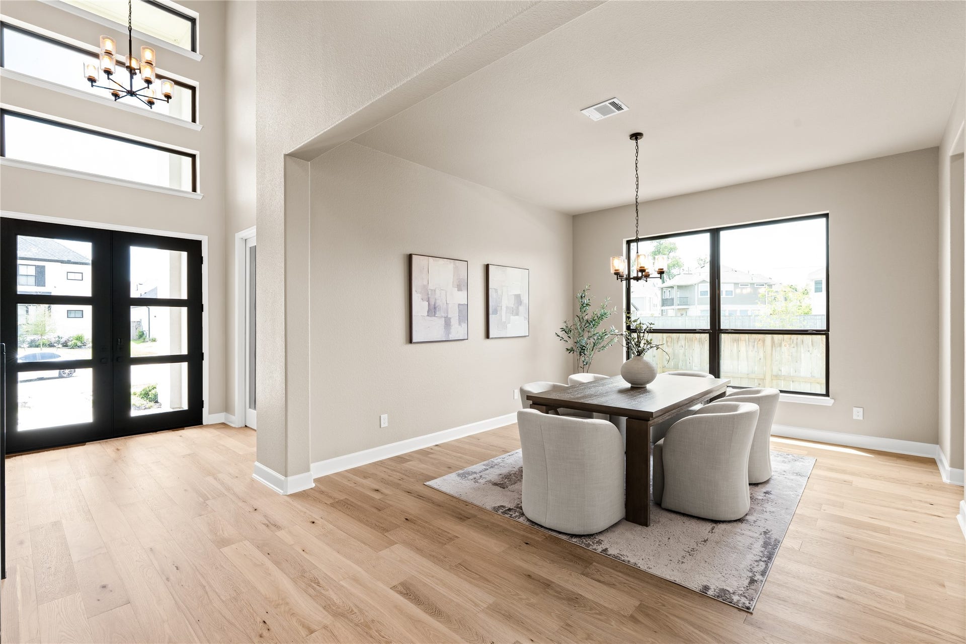 9607 Maple Wood Drive, Missouri City, TX 77459 Bright and inviting, this open-concept dining room features large windows, modern light fixtures, and beautiful hardwood floors, perfect for versatile living and entertaining. *Virtually Staged*