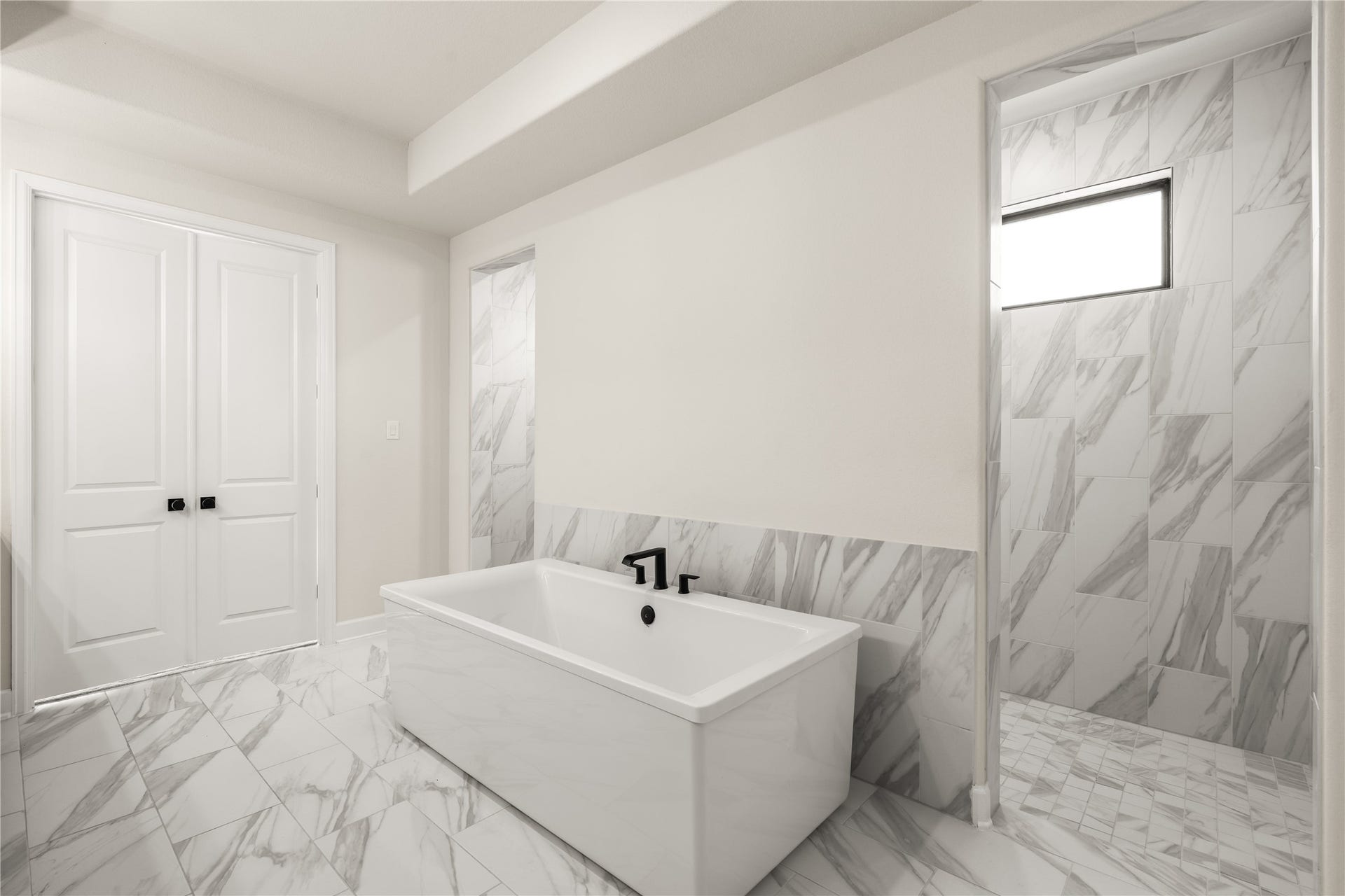 9607 Maple Wood Drive, Missouri City, TX 77459 Opulent bathroom featuring a sleek freestanding tub, elegant marble, and a spacious walk-in shower, offering a spa-like retreat after a long day.