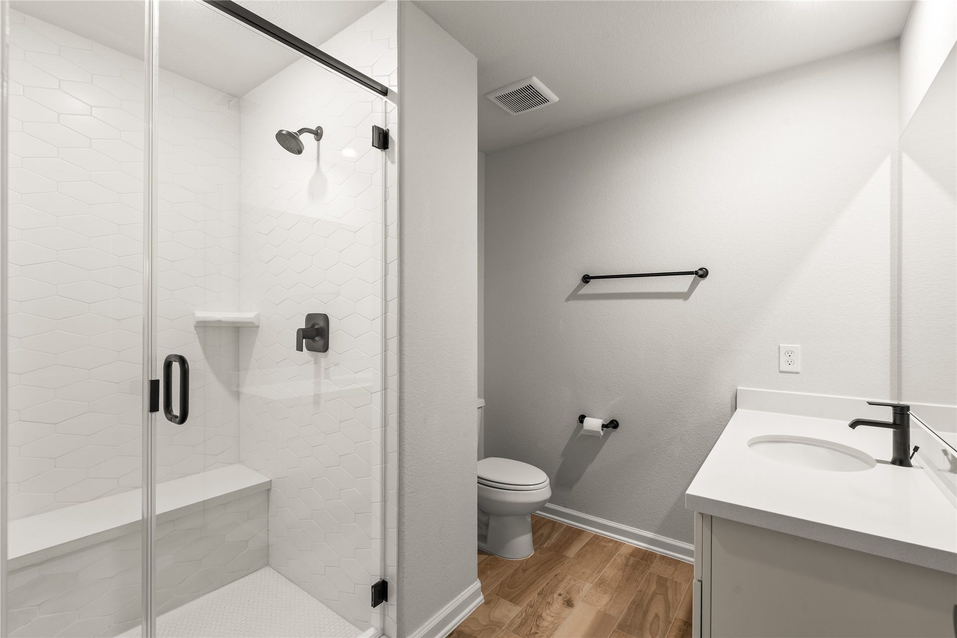 9607 Maple Wood Drive, Missouri City, TX 77459 Modern bathroom featuring a sleek glass-enclosed shower with stylish fixtures, a pristine vanity, and elegant wood flooring.