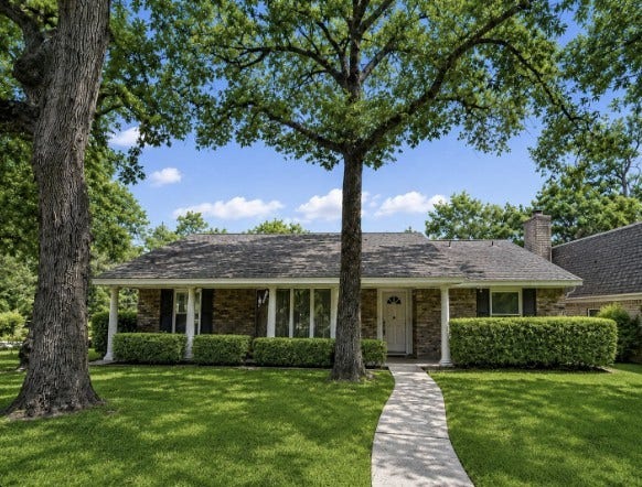 401 Shadywood Circle, Conroe, TX 77304 Charming brick home shaded by mature trees and lush landscaping.