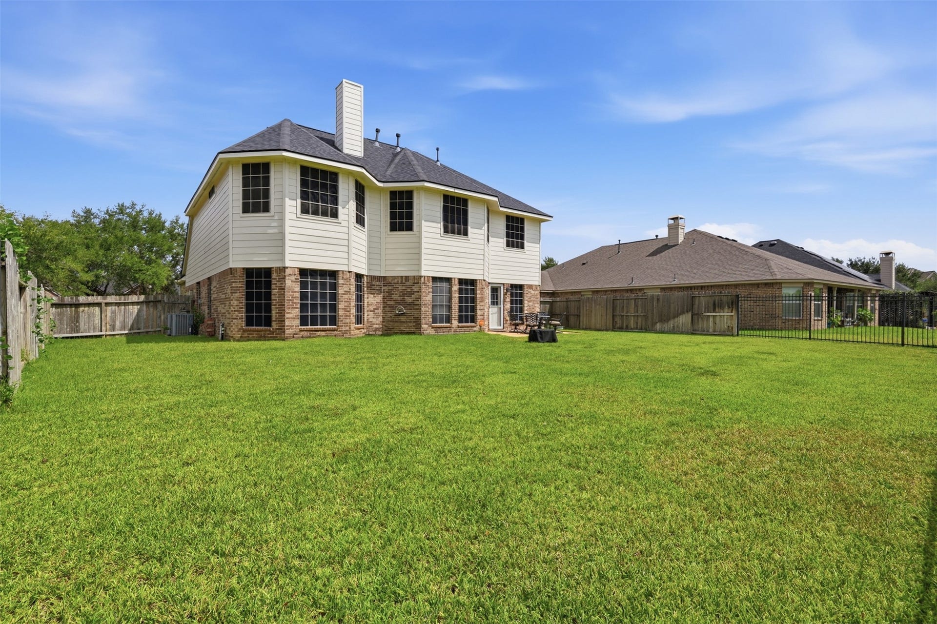 13806 Cove Landing Lane, Rosharon, TX 77583 The rear exterior showcases a spacious backyard, two-story elevation, and easy access to the outdoor living area.