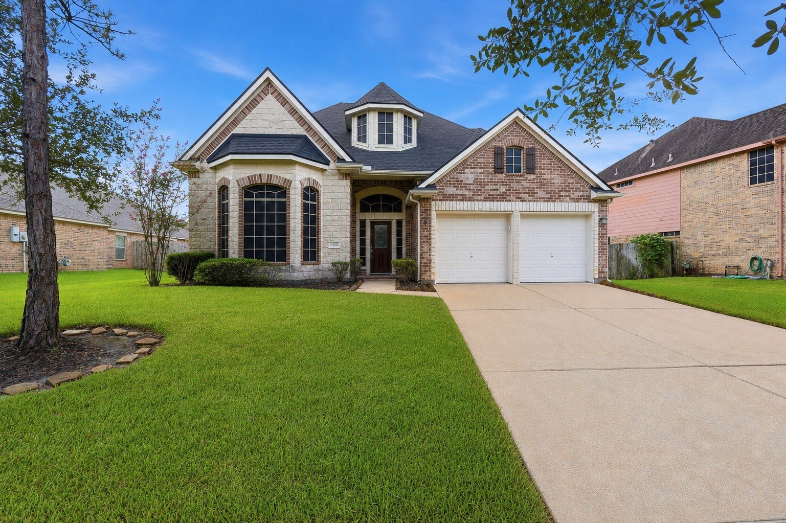 13806 Cove Landing Lane, Rosharon, TX 77583 An impressive 4-bedroom, 3.5-bath home in Savannah Cove, 13806 Cove Landing Lane showcases a striking brick-and-stone exterior, mature trees, and inviting curb appeal.