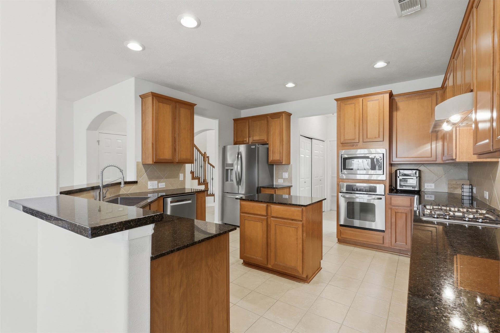 13806 Cove Landing Lane, Rosharon, TX 77583 This well-equipped kitchen offers a center island, breakfast bar, stainless steel appliances, and plentiful counter and cabinet space.