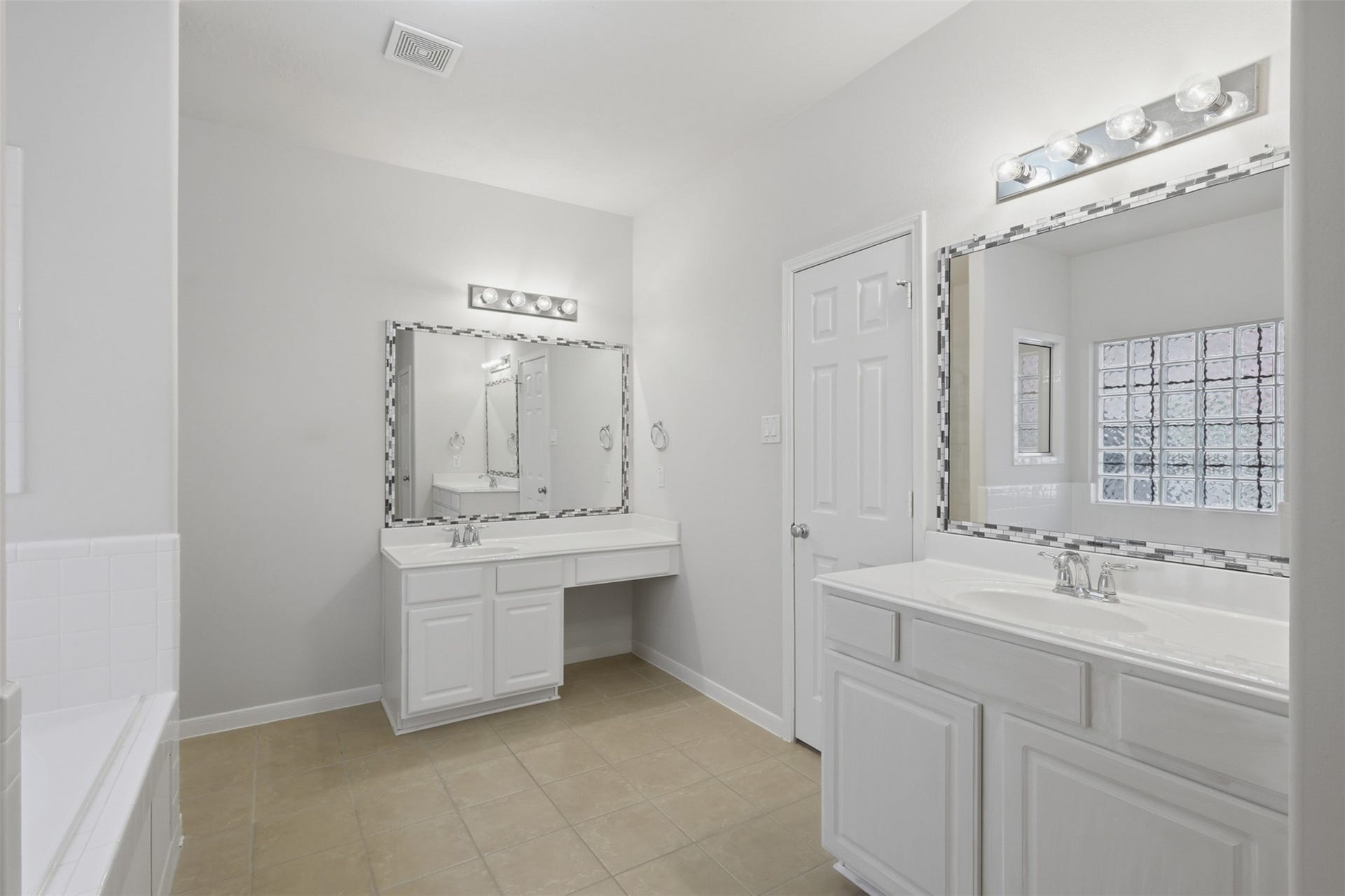 13806 Cove Landing Lane, Rosharon, TX 77583 The primary bath offers separate vanity areas, ample storage, tile flooring, and a bright, functional layout.