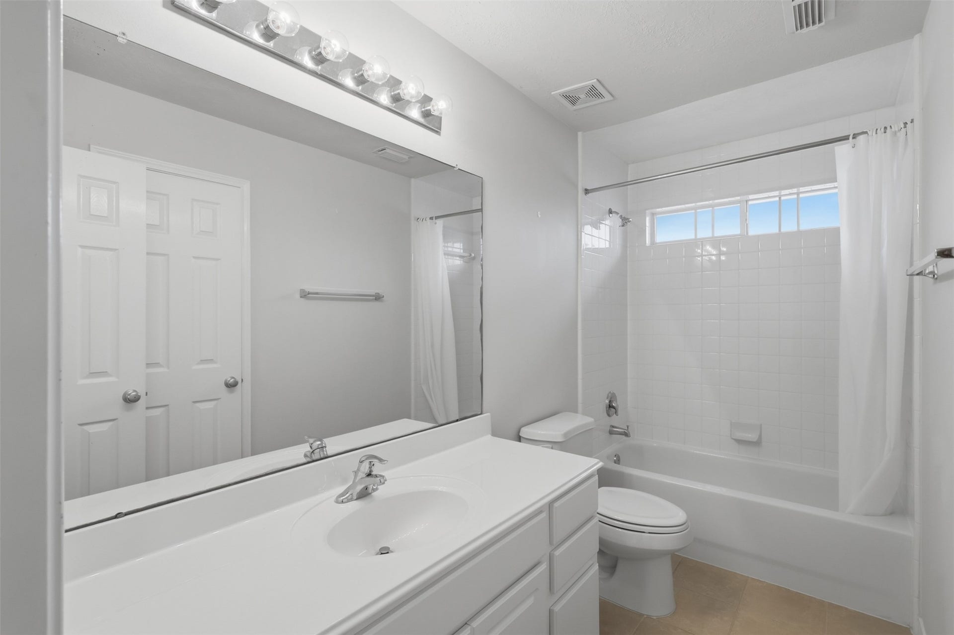 13806 Cove Landing Lane, Rosharon, TX 77583 This full secondary bath includes a spacious vanity, tub-and-shower combination, and natural light from the transom window.