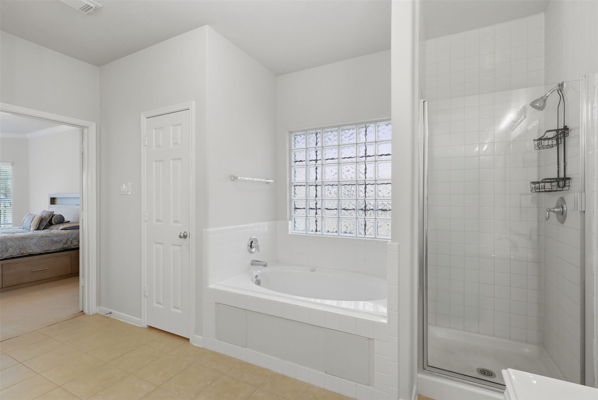 13806 Cove Landing Lane, Rosharon, TX 77583 A soaking tub, separate walk-in shower, and glass-block window complete the spacious primary bath.