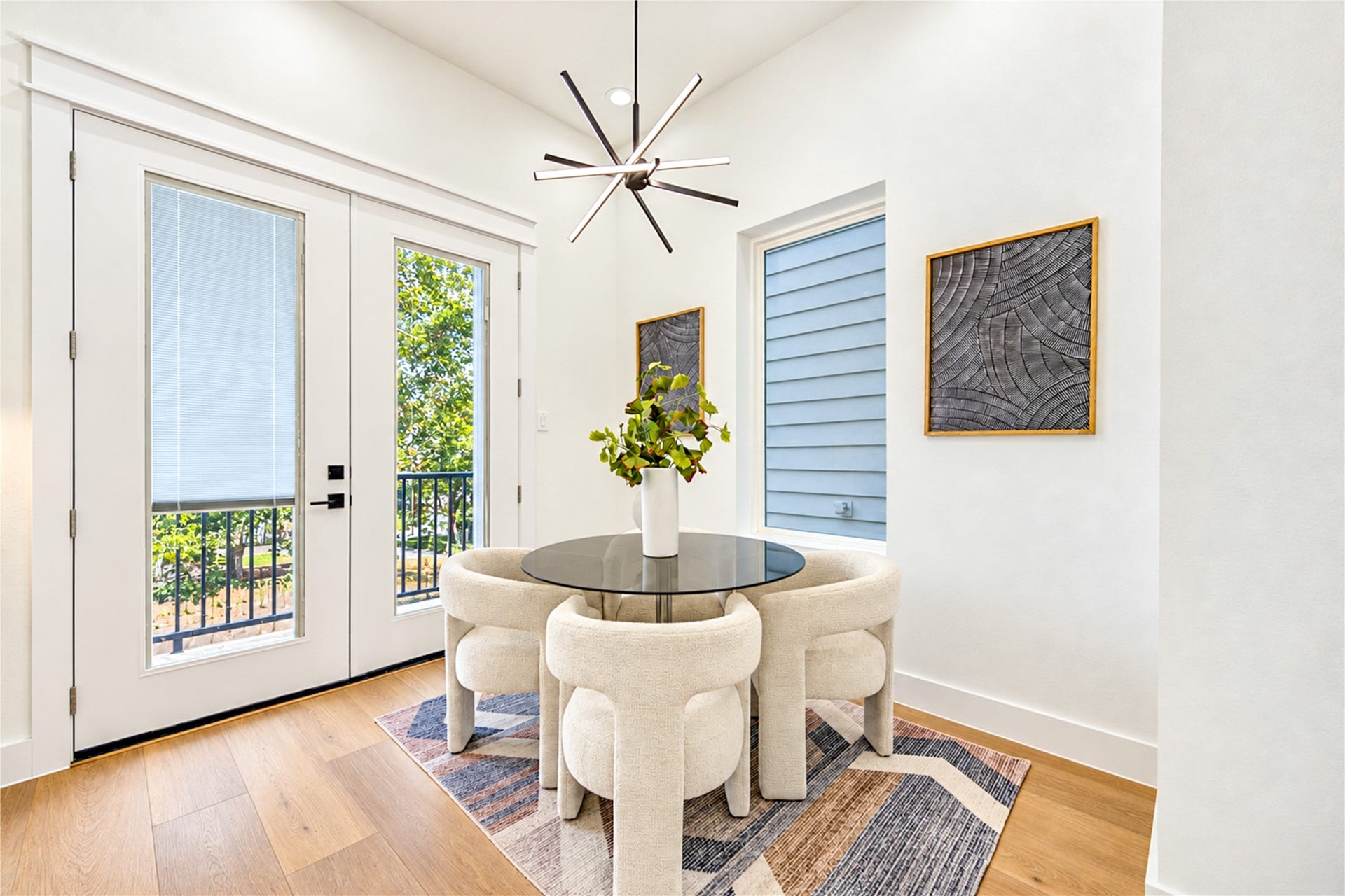 Dining nook with modern lighting, wide-plank flooring, and abundant natural light.