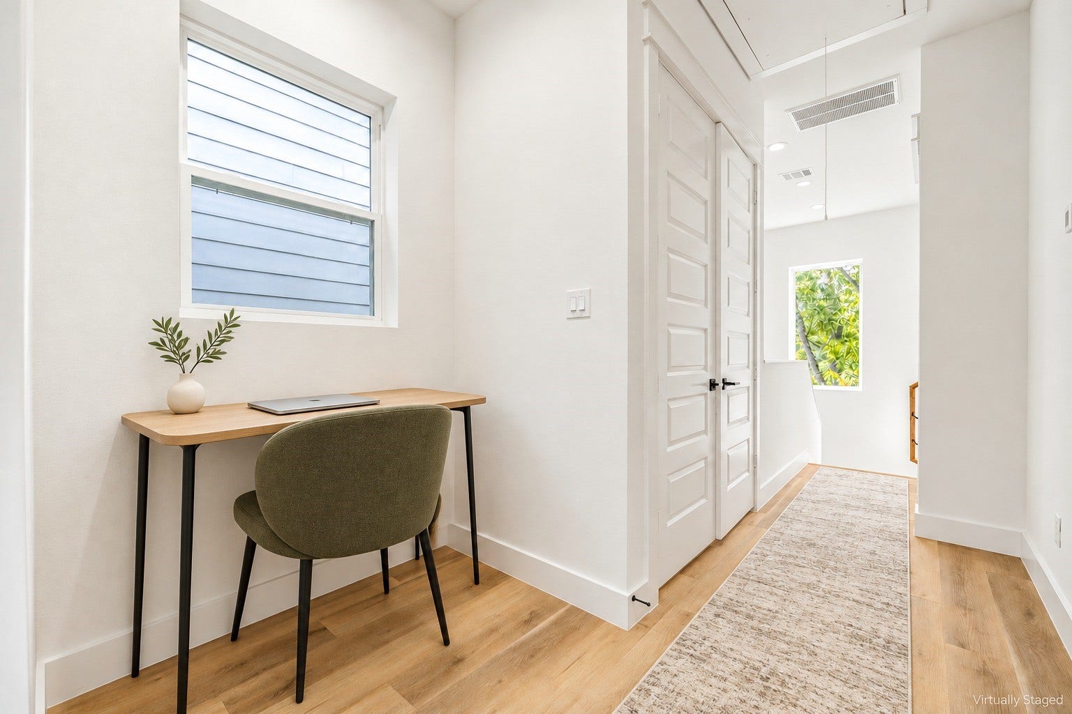 Functional landing space optimized with a built-in pocket office, warm wood flooring, and a bright hallway layout. *Virtually staged