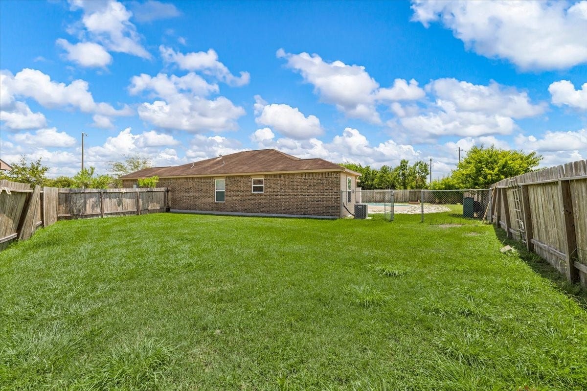 422 Hawks View Drive, La Marque, TX 77568 Completely fenced in grassy area on the opposite side of the pool, for dogs or garden!