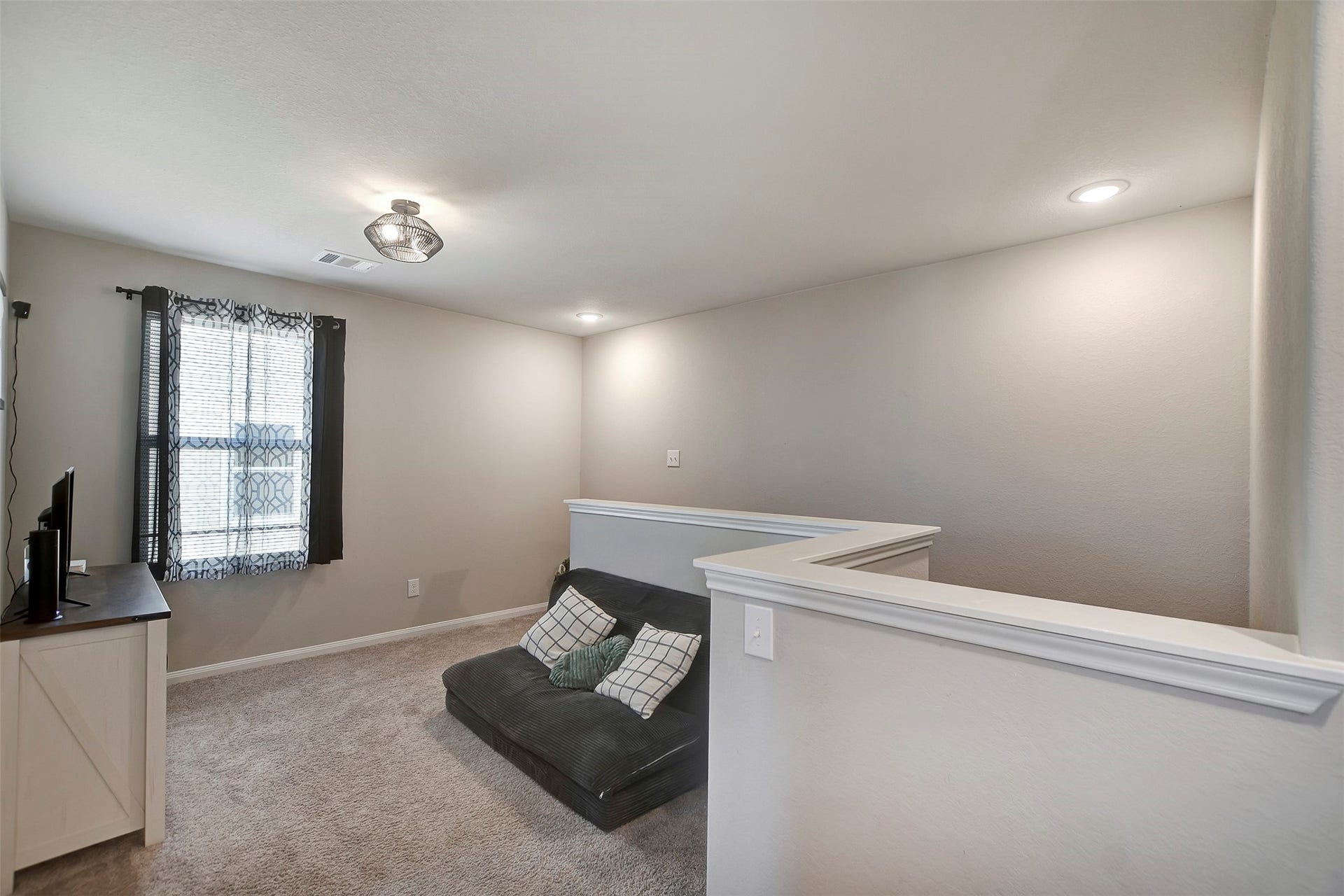 Versatile upstairs loft perfect for a second living area, game room, or home office.
